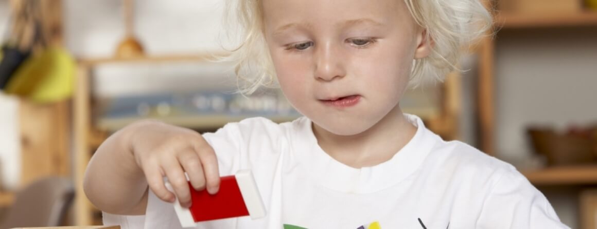 Young child holding a red card.