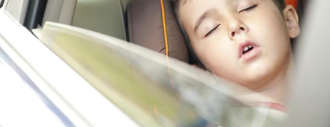 Young boy asleep in the back seat of a car