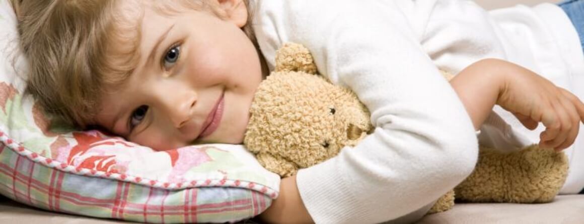 Toddler lying down with her teddy