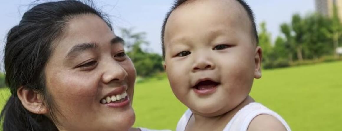 Smiling woman holding a happy infant