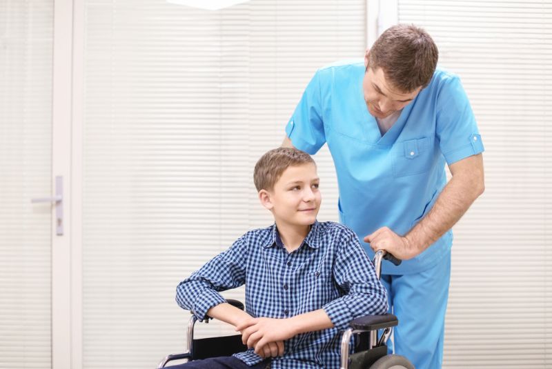 A muscular dystrophy patient in a wheelchair with a nurse