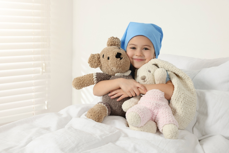 A cancer patient in bed with toys