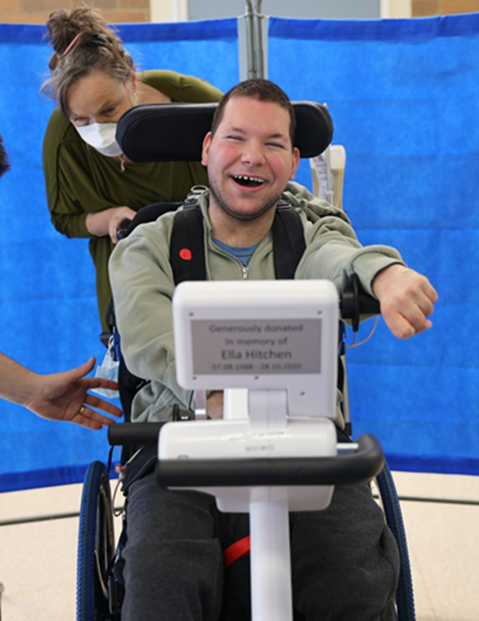 A young adult with cerebral palsy using a motorised cycling device