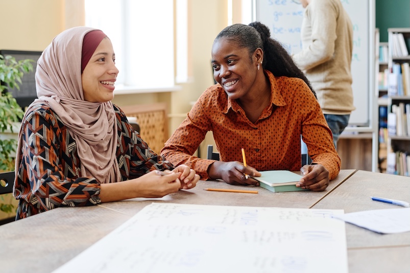 Two young women talking happily