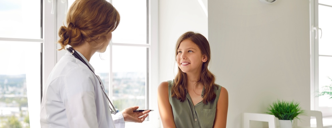 A young adolescent girl talks to a doctor