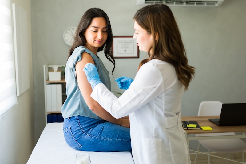 A doctor gives a young girl a covid vaccine