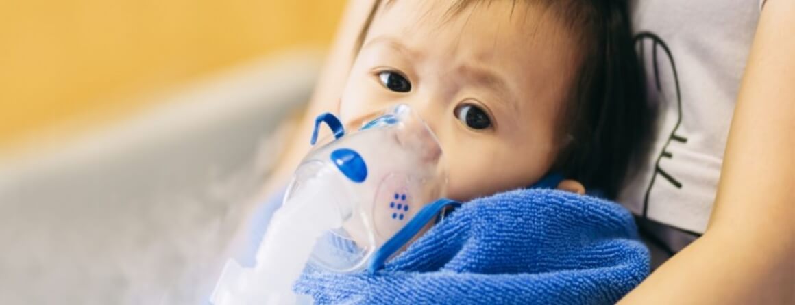 Infant wearing an oxygen mask over their mouth and nose