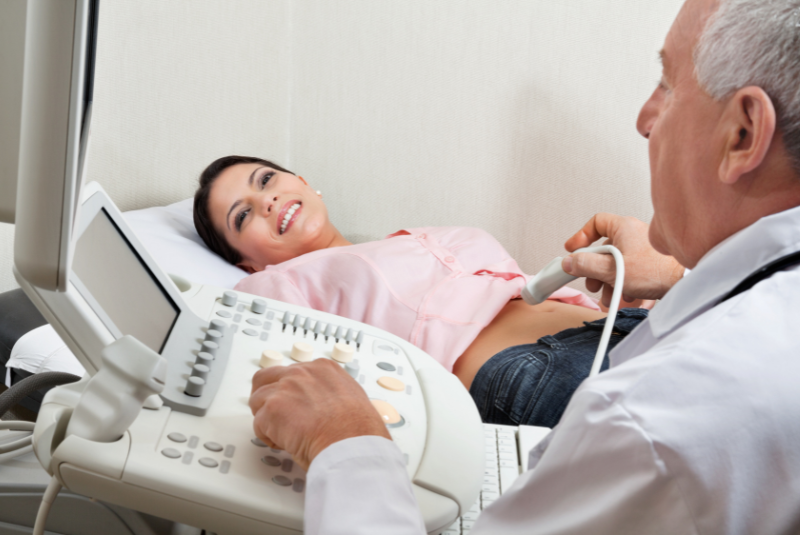 happy pregnant woman with a doctor getting an ultrasound