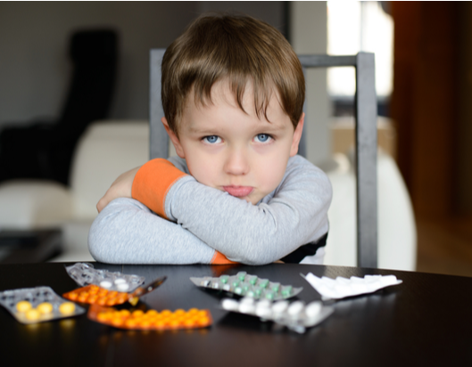 Child sitting down with medication