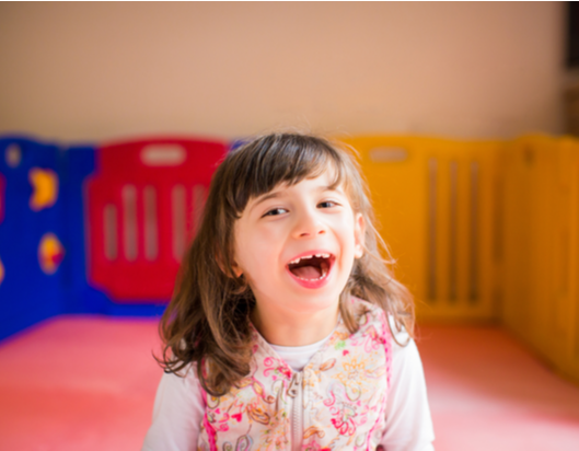 Little girl in play room laughing