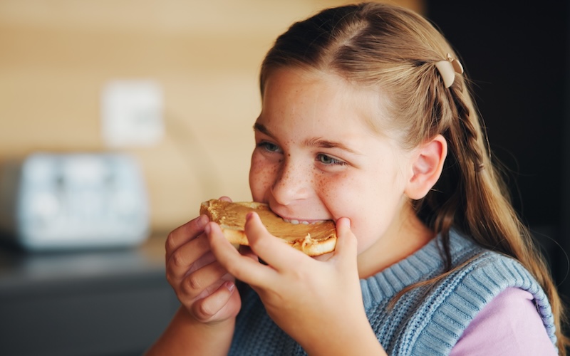 Child eating peanut butter toast
