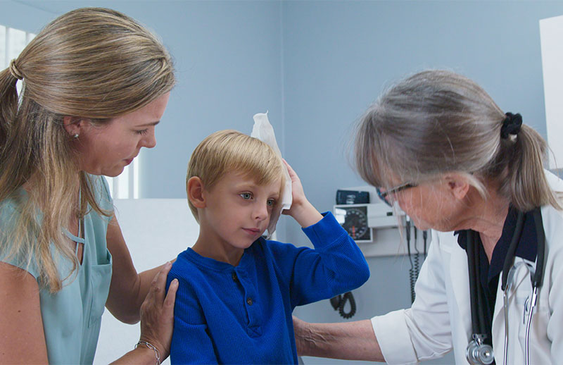 Boy at doctor's holding his head