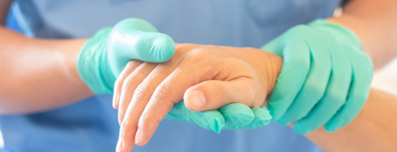 Hand in medical glove holding another hand