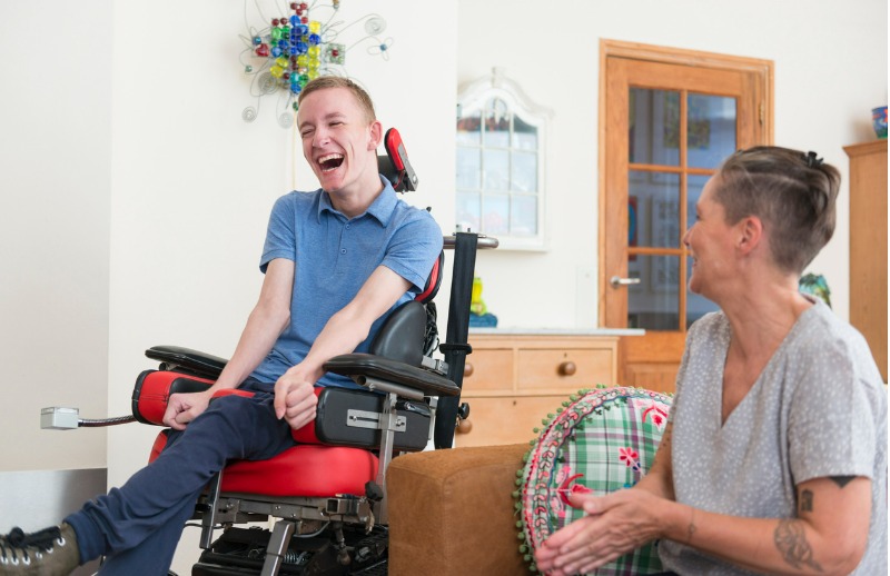 Man in a wheelchair laughing with a friend