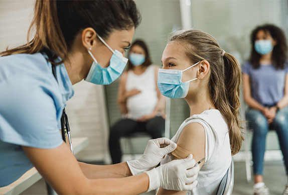 Nurse giving vaccine to teenager