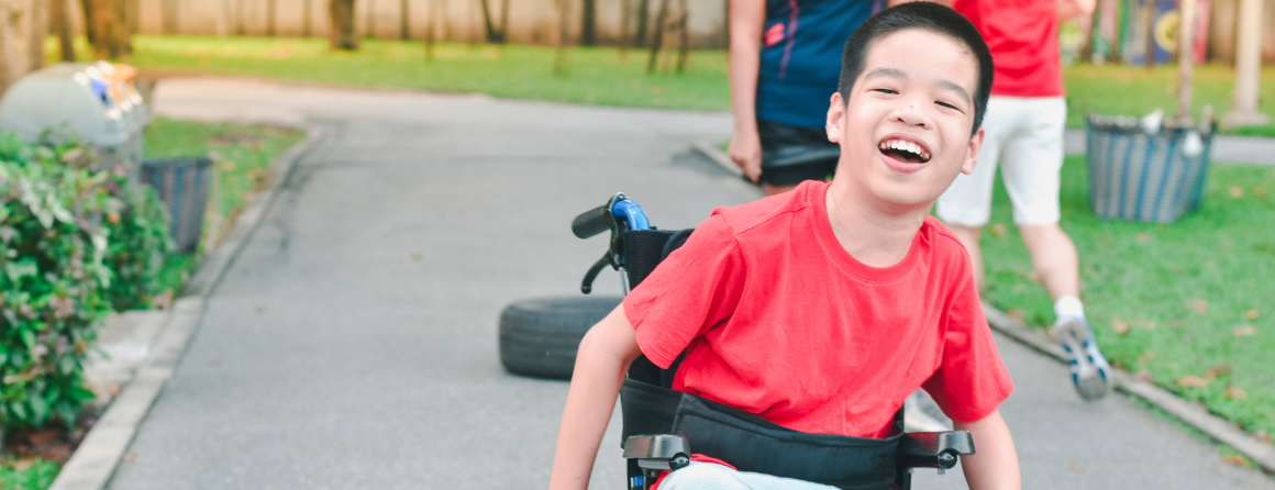 Happy disabled boy a on wheelchair is play and learn in the outdoor park with other people