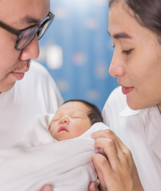 Asian parent looking at newborn